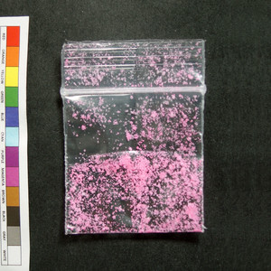 A transparent polythene bag containing remnants of a bright pink powder.